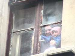 donna con bambino da una finestra dello stabile okkupato di via adda, durante lo sgombero
